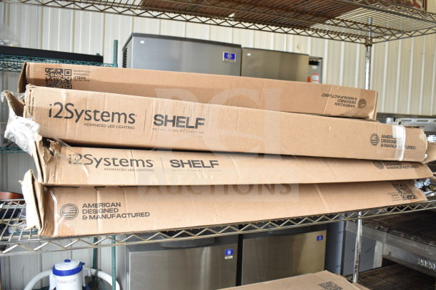 6 boxed i2Systems advanced LED light fixtures on metal shelf. Boxes marked "SHELF Retail Display Lighting," American made.