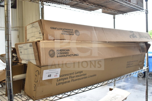 Boxes containing i2Systems light fixtures and other items on a metal shelf. Box marked "American Designed & Manufactured."