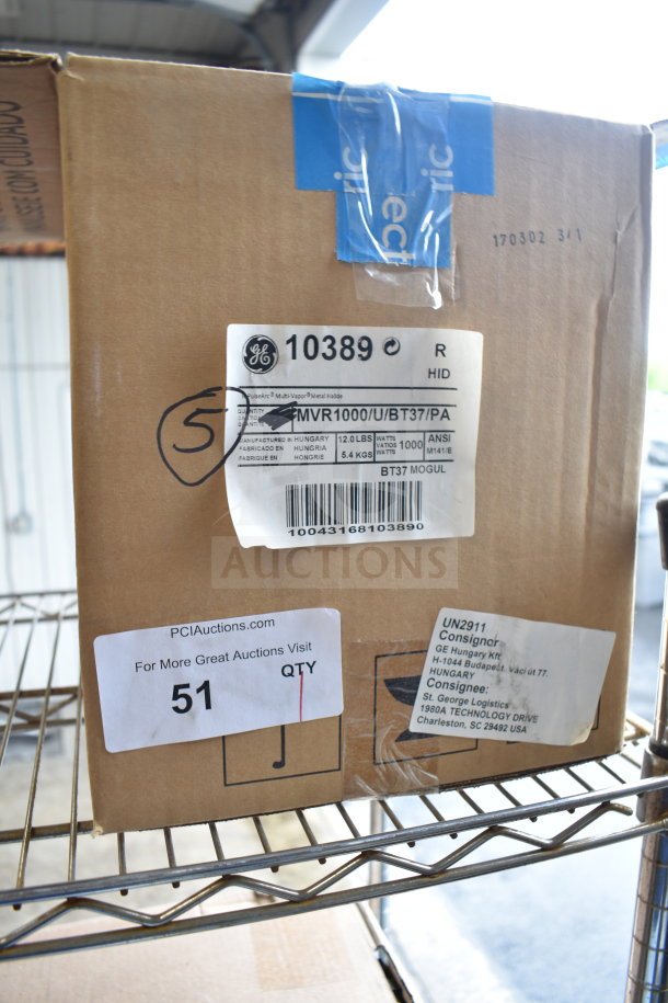 Box of General Electric GE MVR1000/U/BT37/PA lights, labeled with manufacturer's information and auction tag 51, on storage rack.
