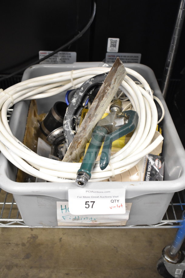 Lot includes basin stopper, chain, hoses, and fittings in a plastic bin marked "QTY v-lot" with visible PCI Auctions label.