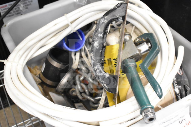 Lot of various items in a bin including a basin stopper, chain, tubing, and a handle, in used condition.