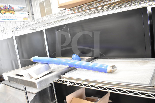 Four various items, including black metal panels, placed on metal shelves. Blue rolled item included. Good condition.