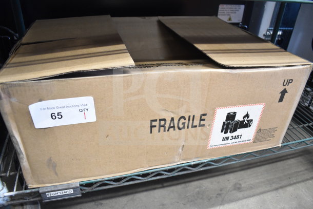 Box labeled "Fragile" and "UN 3481" on shelf, containing various items including body and hair mist. Auction tag "65".