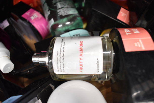 Box of assorted items featuring a Dossier Fruity Almond body mist bottle.