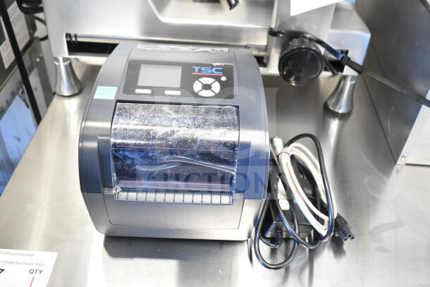 TSC TC210 Thermal Transfer Label Printer, good condition, features display panel, includes power cords, TSC branding visible.