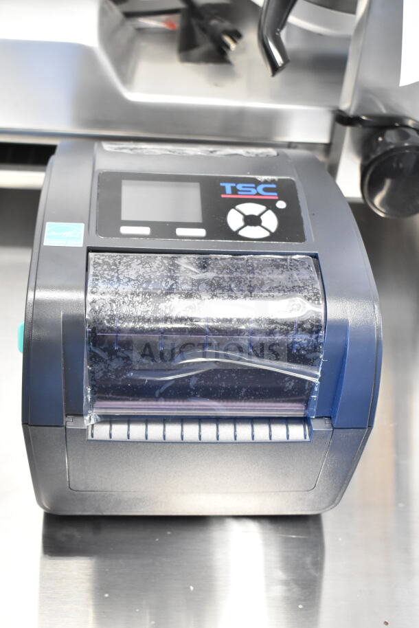 TSC TC210 Thermal Transfer Label Printer, compact design, visible TSC branding, digital display, clear plastic cover, good condition.
