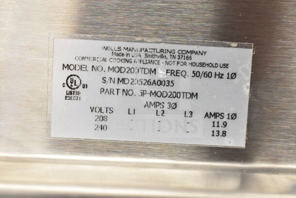 Label for Wells MOD200TDM Hot Food Well showing model, serial number MD20526A0135, voltage and amps details.