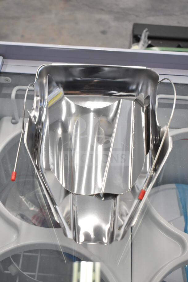 Stainless steel items with visible reflective surface and red-tipped wires, part of 4 new scratch and dent auction lot.