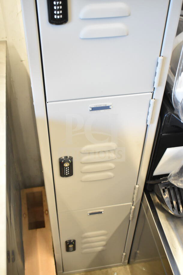 Brand new gray metal locker, four-tier, one wide, 6' high, 15" deep, assembled, combo locks, minor scratches.