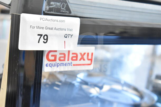 "Galaxy Replacement Merchandiser Door with scratches and dents, brand label visible, auction tag number 79."