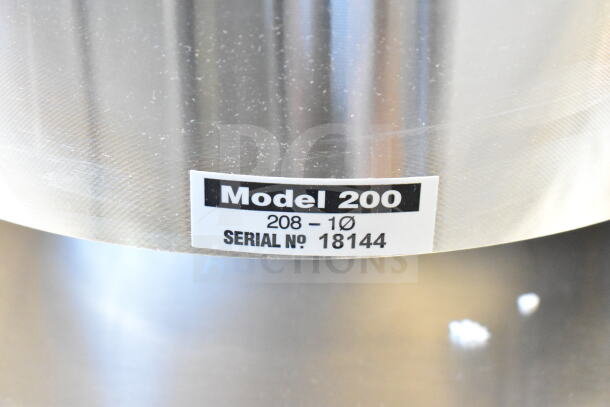 Brand new Salvajor 200 commercial garbage disposer, 208 volts, 1 phase, 2 hp, with model and serial number label visible.