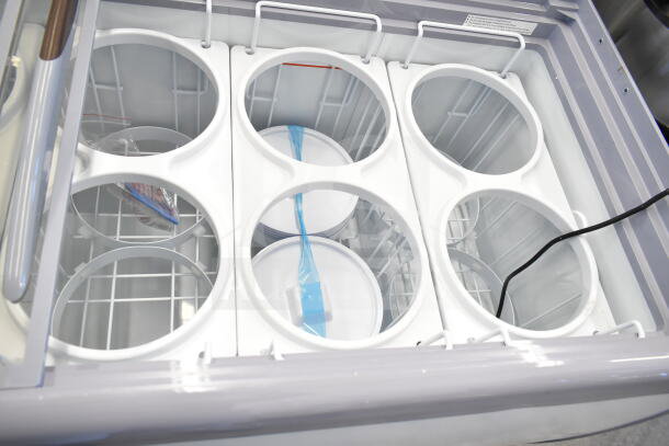 Brand new Avantco 360ADC12N 71" ice cream dipping cabinet, 115V, 1 phase, customizable storage, minor scratches, visible racks.