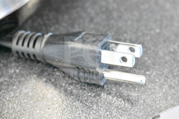 Black power plug for Galaxy 177ACR22SS roaster oven, shown on textured surface, highlighting electrical compatibility.