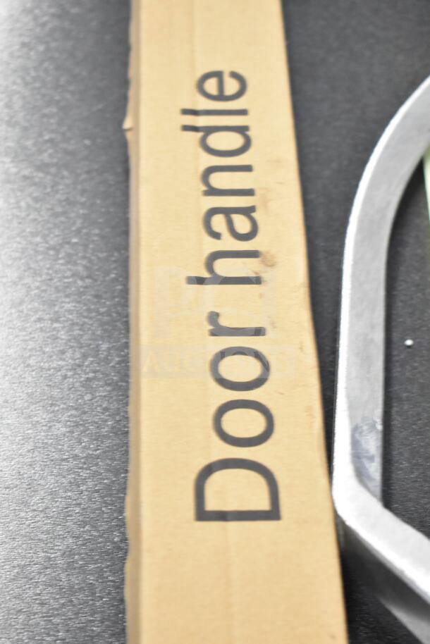 Cardboard packaging labeled "Door handle" alongside a metal piece, part of a scratch and dent auction lot.