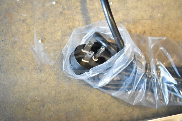 Power cord of Danby DBC434A1BSSDD beverage refrigerator, wrapped in plastic for protection, showing a three-prong plug.