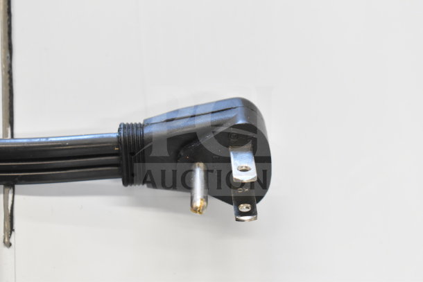 Power cord for Ice-O-Matic ICEU220FA5 ice machine, showing a three-prong plug with visible engravings on the prongs.