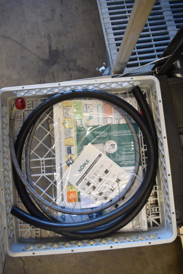 Brand new 2025 Noble 495LTUC24 low-temp undercounter dishwasher, shown in packaging with installation materials and manual.