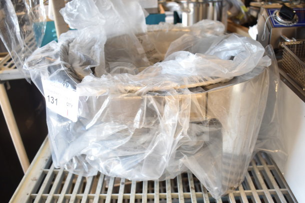 Brand new round chafer dish, stainless steel, covered in plastic wrap, labeled "131 QTY." Some visible scratches.