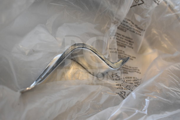 The image shows a brand new scratch and dent round chafer dish. It appears partially wrapped in protective plastic, highlighting its condition and the reflective metal surface.