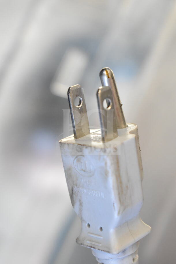Close-up of a power plug labeled "THE WONDERFUL." Background is blurred. The plug shows minor wear.