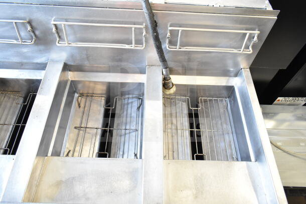 Frymaster BIGLA430CSD 3-bay gas fryer with commercial casters, stainless steel body, clean condition, visible fryer baskets.