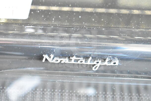 Nostalgia NRMO7BK6A countertop microwave showing brand logo, 120 volts, 1 phase, minor surface marks visible.