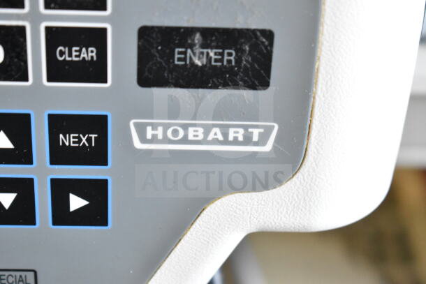 Hobart Quantum-1 kitchen scale close-up, shows control panel and logo. No power cord. Model accommodates 120V, 1 Phase.