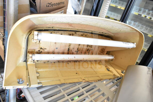 Five used bug zappers on a shelf, 120 volts, 1 phase, with visible wear and insect residue inside. Part of auction bid.