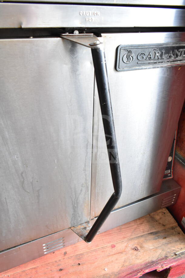 Garland commercial convection oven with solid doors, thermostatic controls, in used condition. Visible "Caution Hot" marking.