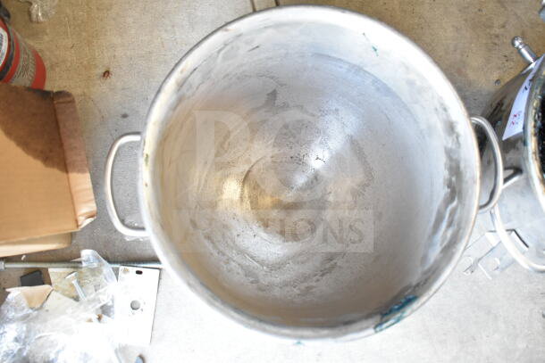 Stainless steel mixing bowl with handles, showing signs of wear. Ideal for kitchen or industrial use.