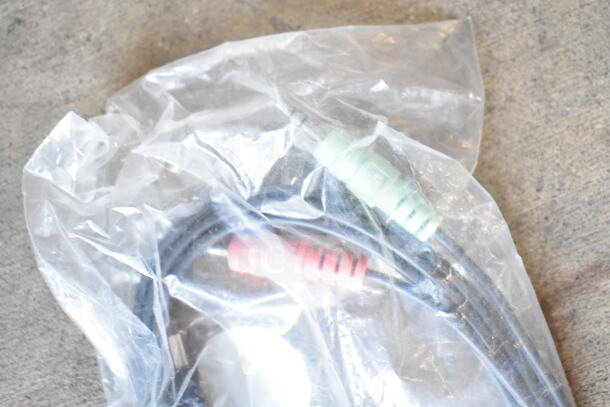 Sealed bag with a pair of audio cables featuring red and green connectors, possibly part of a lot including bowls and portafilters.