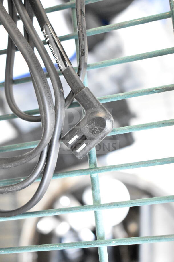 Black power cord with prong connector for Dual Lite LMW40I-FW Emergency Light visible against a wire rack.