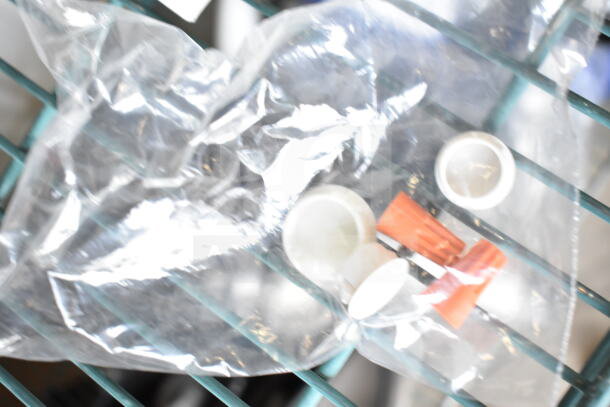 Bag containing installation components for Dual Lite LMW40I-FW emergency light, including connectors and caps.