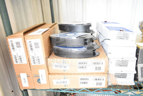 Assorted office equipment including boxed Motorola devices and CB300-D Digital Callbox units on metal shelves.