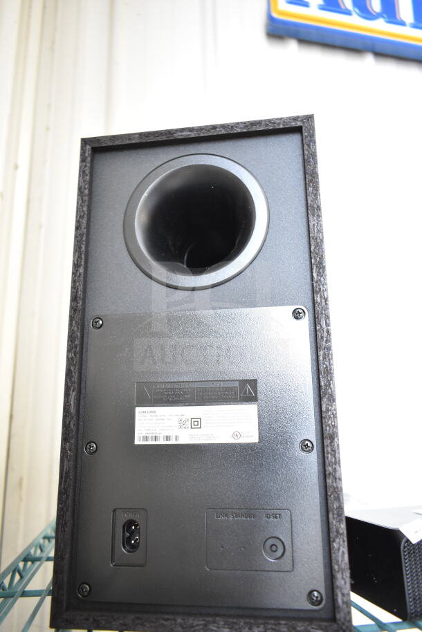 Samsung PS-WR45BB Speaker, rear view showing power input, control ports, and manufacturer's label. Sleek black finish.