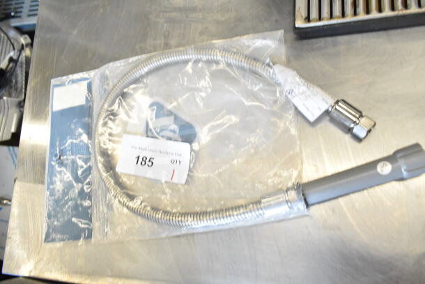 T&S B-0036-H 36" flexible stainless steel hose in clear packaging, includes auction tag reading "185." New condition.