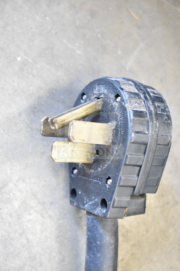 Close-up of a power plug for a Fetco CBS-2052e20 commercial coffee machine. Three prongs visible.