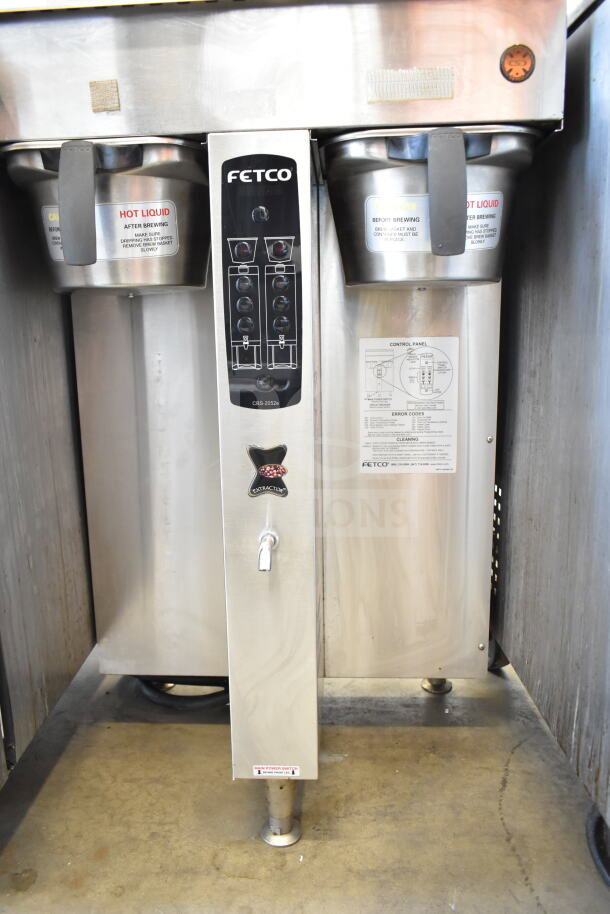 Fetco CBS-2052e20 commercial double coffee machine, stainless steel, 120/208-240V, 1 phase. Control panel and warning labels visible.