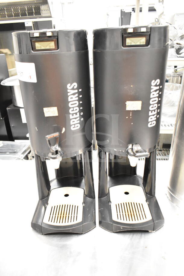 Three Gregory's Coffee satellite servers, black, used condition, visible wear on surface, ideal for bulk beverage dispensing.