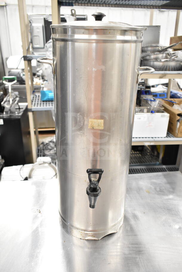 Stainless steel satellite server with spigot, handles, and lid. Slight wear, suitable for large beverage storage.