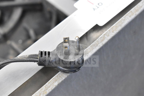 Wolf Commercial Countertop Gas 8 Burner Range plug detail; shows a black three-prong plug over metal surface.