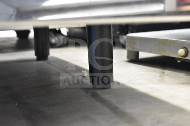 Nespresso Aguila 420 Commercial Espresso Machine base, shown from ground level. Visible are metal supports and flooring.