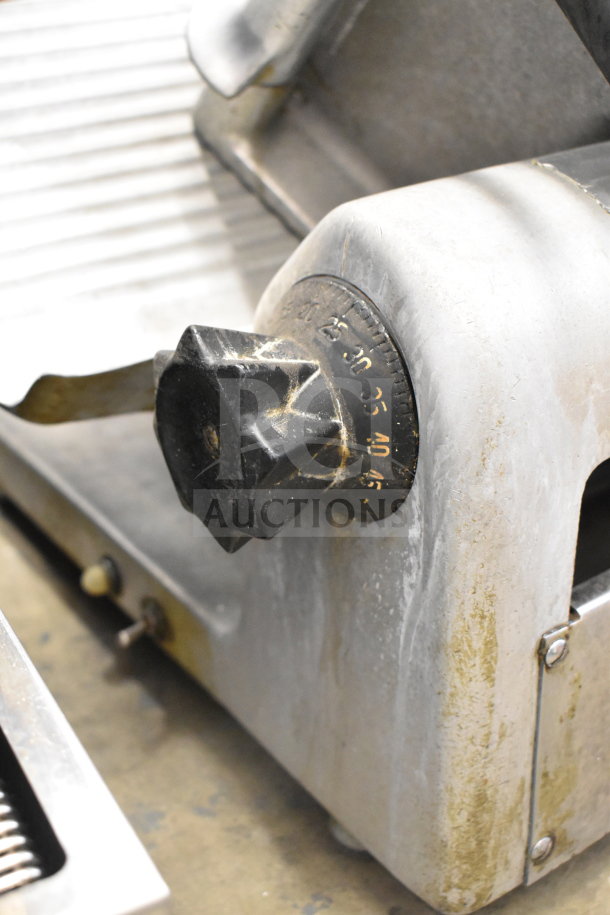 Commercial countertop meat slicer, 115 volts, 1 phase, with adjustable thickness knob, showing signs of wear.