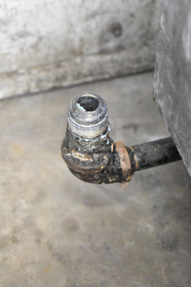 Close-up of a rusted pipe fitting on a gas-powered deep fat fryer. The condition suggests wear and potential need for maintenance.