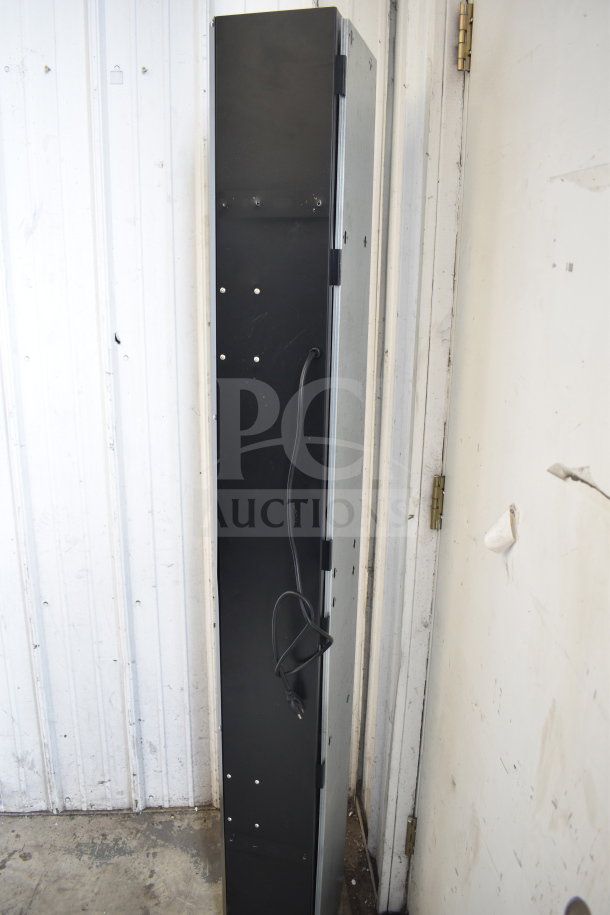 Black air curtain, 115 volts, 1 phase. Vertical orientation, visible power cord, metal frame, in good condition.