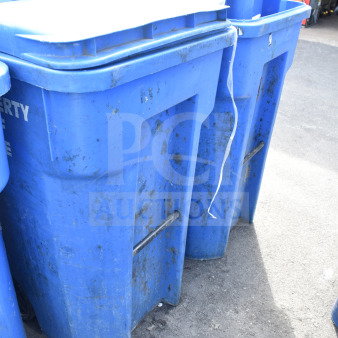 Three blue poly trash cans, used condition, on pavement. Features handles and lids. Sturdy build, ideal for waste management.