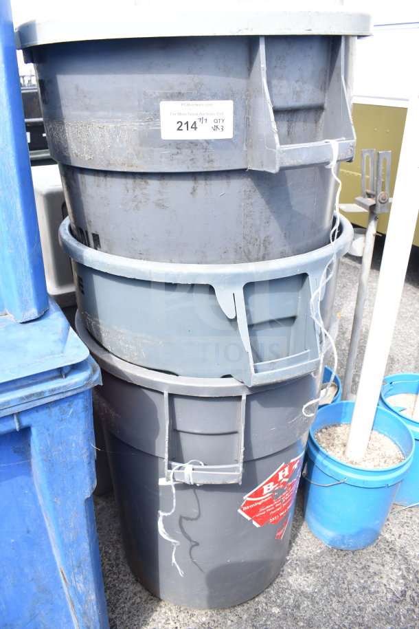 Three stacked gray poly trash cans with visible wear, auction label "214," and red warning decal.