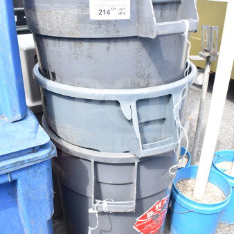 Three stacked gray poly trash cans with visible wear, auction label "214," and red warning decal.