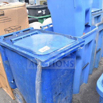 Four blue poly trash cans with lids, showing signs of wear. Includes "Property of" markings. Auction lot of four.