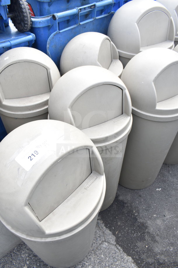6 Tan Rubbermaid poly trash cans, dome lids, gently used. Label visible: "219". Auction: bid multiplies by 6.